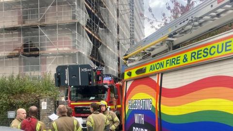 Firefighters outside burnt building