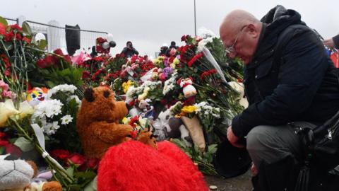 A man mourns at a makeshift memorial for victims of the attack at the Crocus concert hall