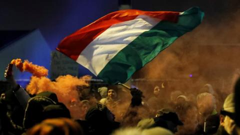 Hungarian national flag and smoke from flares seen in a protest outside the headquarters of the Hungarian state television in Budapest, Hungary, December 17, 2018.