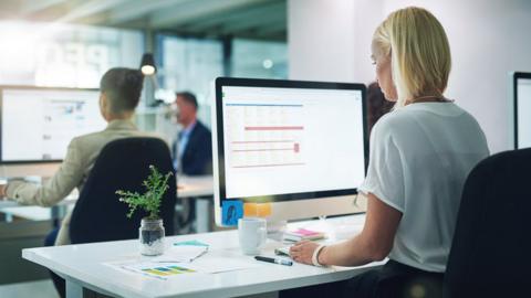 Woman sitting at a computer terminal