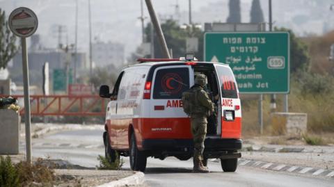 An Israeli soldier stands by an ambulance