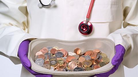 Doctor holding a dish of money