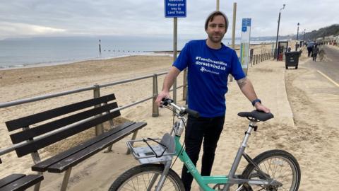 David Haze with bike on sandy beach