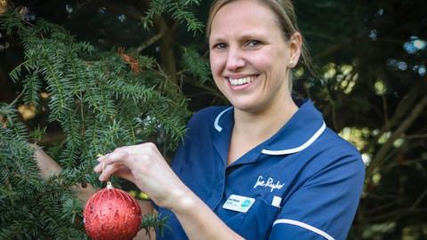 A Sue Ryder nurse decorates a Christmas tree