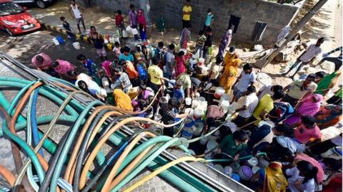 Residents filling empty containers with drinking water from a municipal tanker, at Vivekanand Camp, in Chanakyapuri on April 17 in Delhi