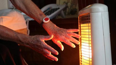 Hands being warmed on an electric heater