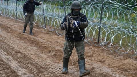 Polish soldiers build a fence on the border between Poland and Belarus