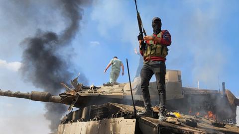 Person holding gun standing on a tank