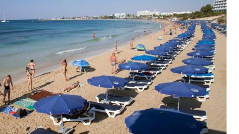 Stock photo of tourists sunbathing on a beach in the resort of Ayia Napa