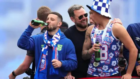 Ipswich Town player on the open-top bus during their promotion parade