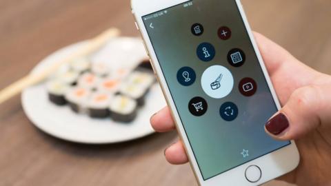 Publicity shot of iPhone pointed at a plate of sushi