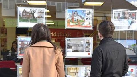 People looking in estate agents window