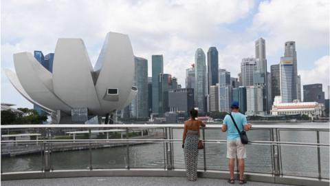 Tourists view the ArtScience Museum (L) in Marina Bay in Singapore.
