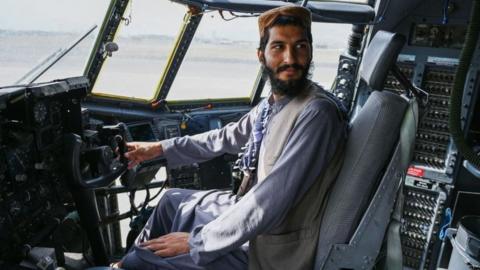 Taliban fighter in US aircraft at Kabul Airport