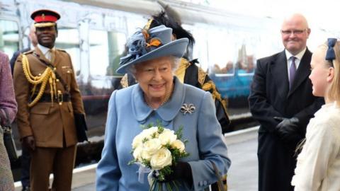The Queen walking from a train