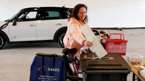 A cyclist casts a ballot in a drive-in polling station during the Dutch general election in Zuidplas, Netherlands, 15 March