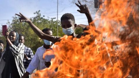 Sudanese protesters block a street with burning tyres during a demonstration demanding civilian rule in the capital Khartoum, 4 January 2022