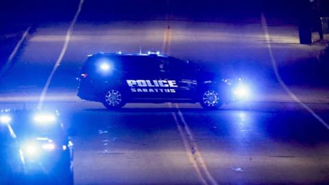 A police car blocks access to a bar where a man reportedly opened fire killing and injuring numerous people in Maine