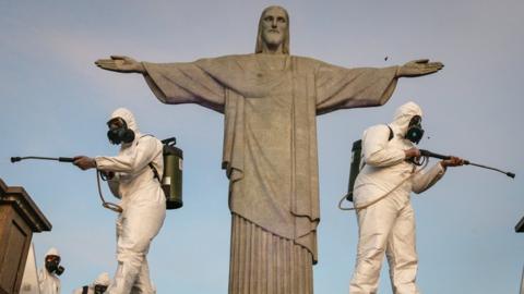 Military personnel disinfect the area surrounding the statue of Christ the Redeemer