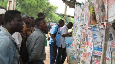 People read headlines at a newspaper stand in Lome, Togo