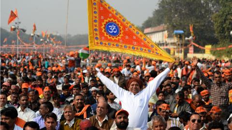 An Indian Hindu hardliner holds a religious flag as he participates in the rally