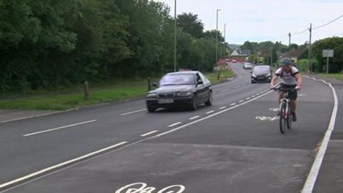 Cyclist travels along a cycle lane in Wimborne, Dorset