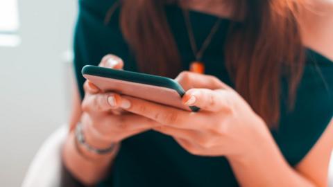 A woman typing on her phone