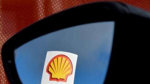 Shell logo is reflected in a car mirror