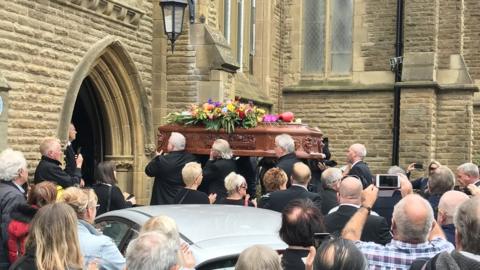 Joe Longthorne's coffin being carried into the church