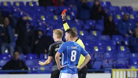 Referee and two footballers