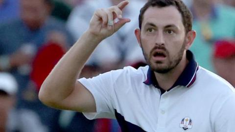 US Ryder Cup player Patrick Cantlay motions to tip his hat to fans despite not wearing one