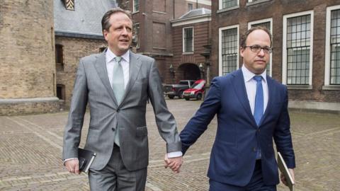 Politicians from Democrats 66 party, Alexander Pechtold (l) and Wouter Koolmees (r), held hands to show support for the movement