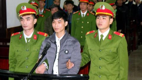 Activist Nguyen Van Hoa (C) standing trial at a local people's court in the central province of Ha Tinh, Vietnam