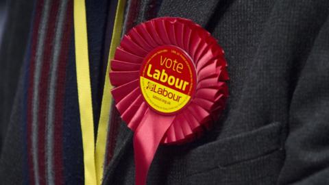 A Labour member wearing a rosette