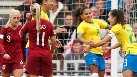 Brazil players celebrate scoring their first goal against England