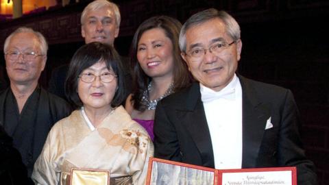 Japan's Ei-ichi Negishi (R) and his family display his Nobel diploma and medal after he received the shared Nobel Prize in Chemistry