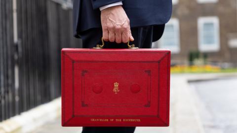 The chancellor holds his red box outside Downing Street
