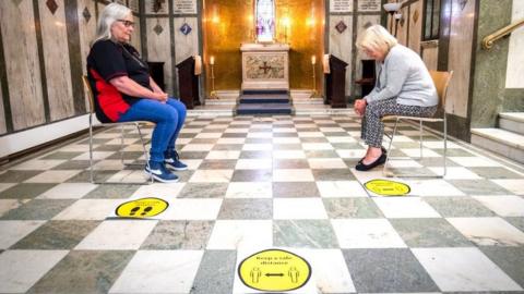 Parishioners Jacqueline Baillie and Linda Farrer pray in the Memorial Chapel at St Cuthbert's, which is now open for private prayer