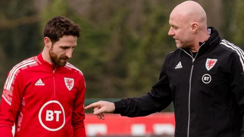 Wales manager Rob Page talks to Joe Allen in training