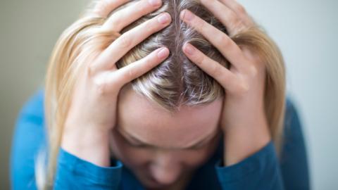 Woman with her head in her hands. Model.