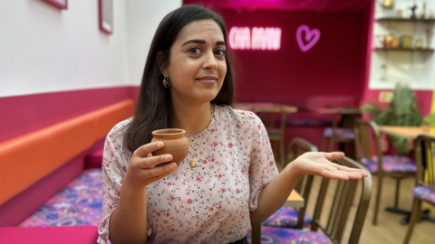 BBC reporter holds cup of Chai