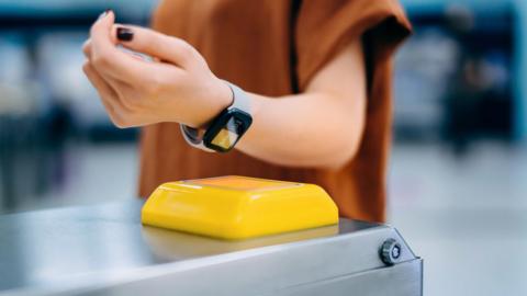A woman tapping a smartphone on a scanner