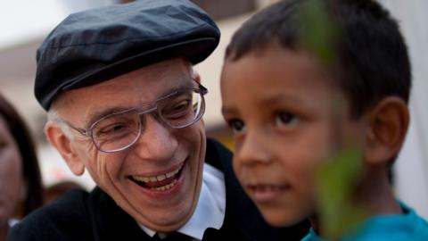 Jose Abreu meets a child as he arrives at a free concert at La Vega in Caracas August 2, 2009