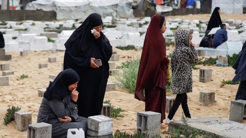 Palestinian women visit graves of people who were killed in the ongoing conflict between Israel and Palestinian Islamist group Hamas, on the day of Eid al-Fitr, in Rafah, in the southern Gaza Strip April 10, 2024
