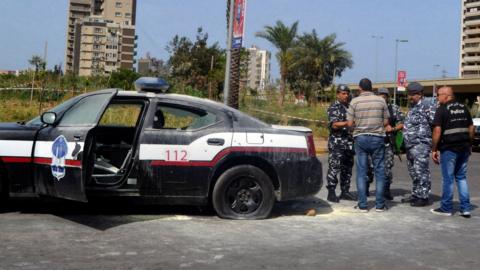 Lebanese security forces stand next to a vehicle shot at by a gunman in the city of Tripoli (4 June 2019)