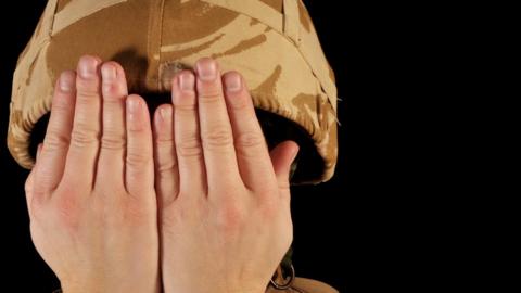 Soldier with hands over face