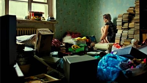 Girl in cluttered room