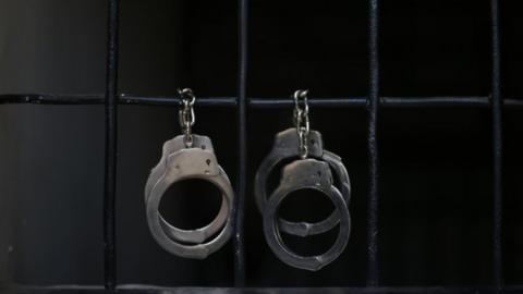Handcuffs hang in a prison. File photo