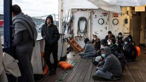 Migrants wait on the boat after they were not allowed to disembark