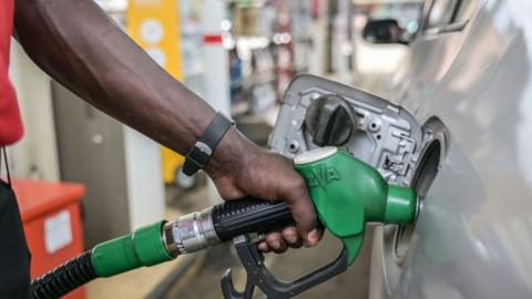 A pump attendant pumps fuel into a car at a gas station in Nairobi, on September 19, 2023